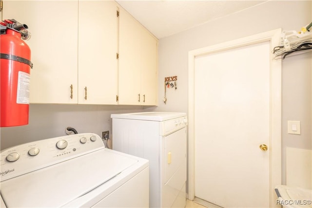 washroom featuring cabinets and independent washer and dryer