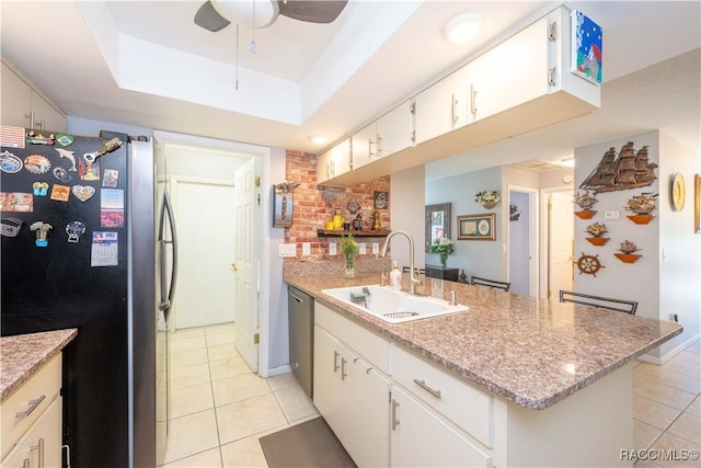 kitchen with stainless steel appliances, white cabinetry, sink, and light tile patterned floors