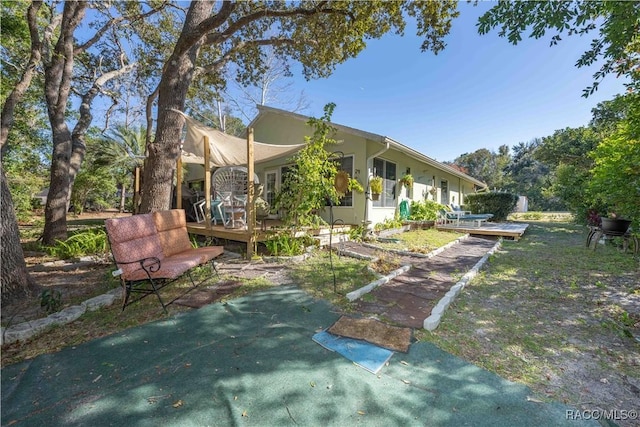 rear view of property featuring a wooden deck