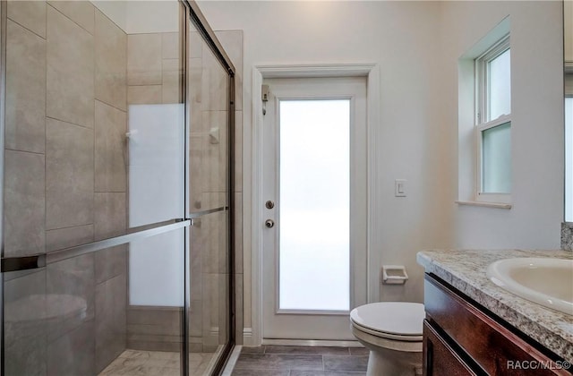 bathroom featuring vanity, toilet, and an enclosed shower