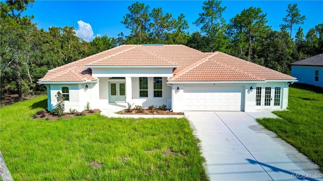 mediterranean / spanish house with a front lawn, a garage, and french doors