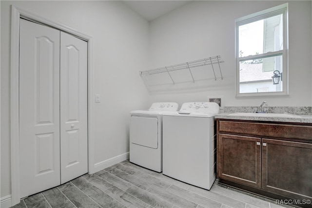 washroom with separate washer and dryer, sink, and cabinets