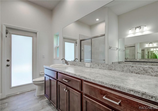 bathroom featuring vanity, toilet, and an enclosed shower