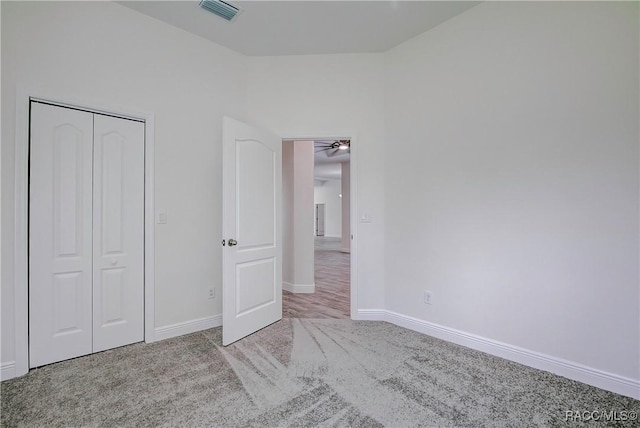 unfurnished bedroom featuring light carpet and a closet