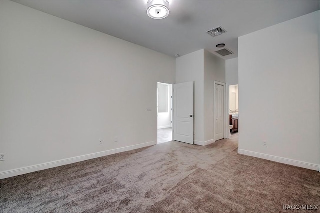 unfurnished bedroom featuring a closet, light colored carpet, and a high ceiling