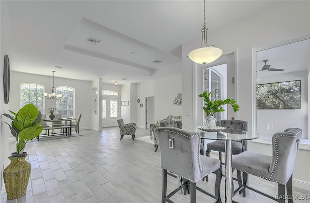 dining room with french doors and ceiling fan with notable chandelier