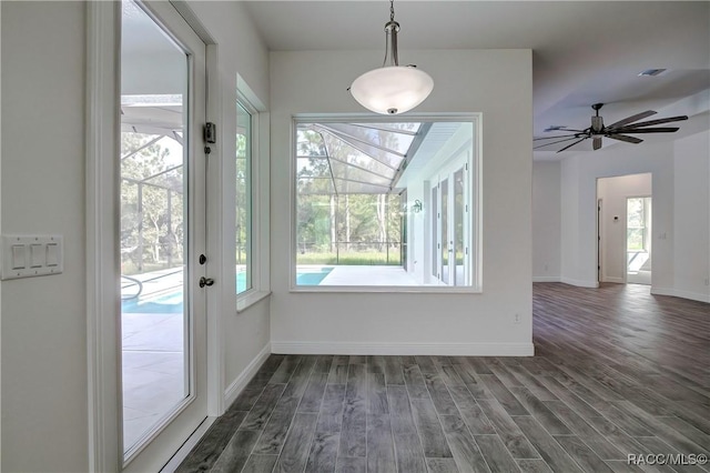 interior space with ceiling fan, dark wood-type flooring, and a wealth of natural light