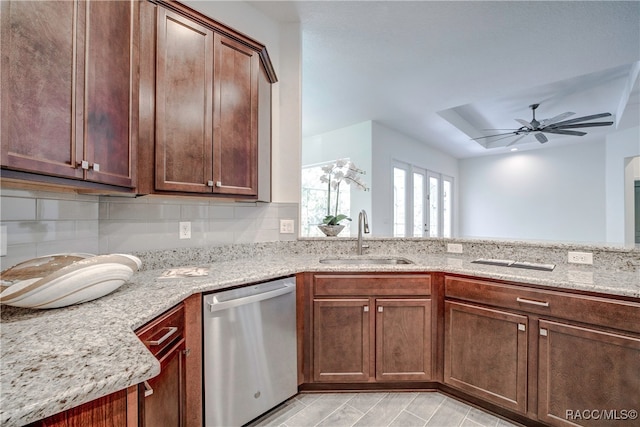 kitchen featuring light stone countertops, stainless steel dishwasher, ceiling fan, and sink