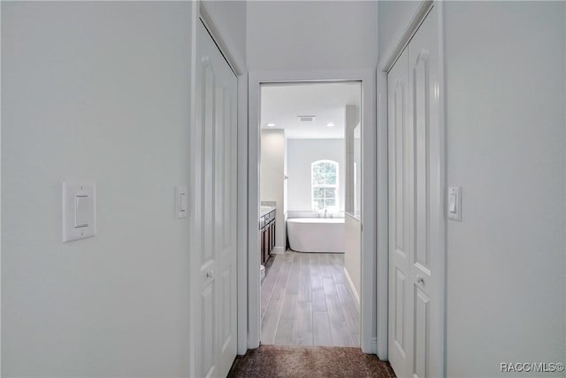 hallway with light hardwood / wood-style flooring