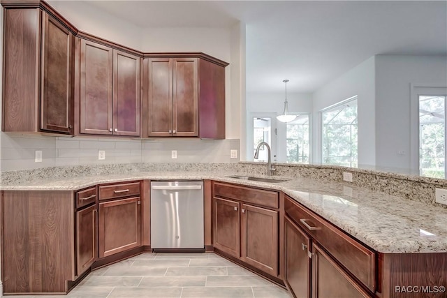 kitchen with decorative backsplash, light stone counters, sink, decorative light fixtures, and dishwasher