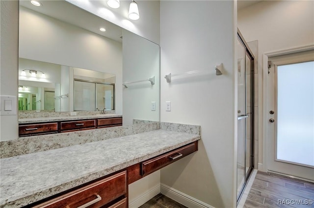 bathroom featuring vanity and a shower with door