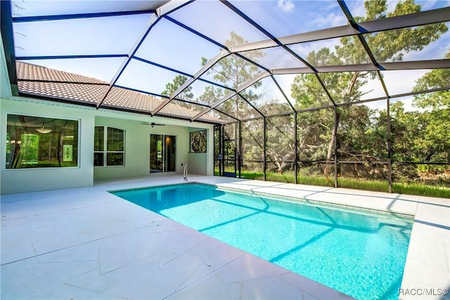 view of swimming pool with ceiling fan, a patio area, and a lanai