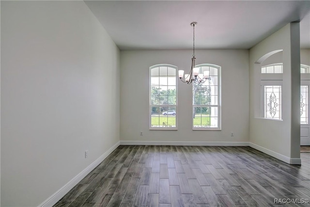 unfurnished dining area featuring hardwood / wood-style flooring and a notable chandelier