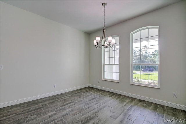 spare room featuring an inviting chandelier and a healthy amount of sunlight