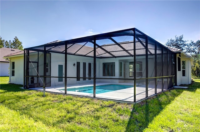 back of house featuring a yard, a patio area, and a lanai