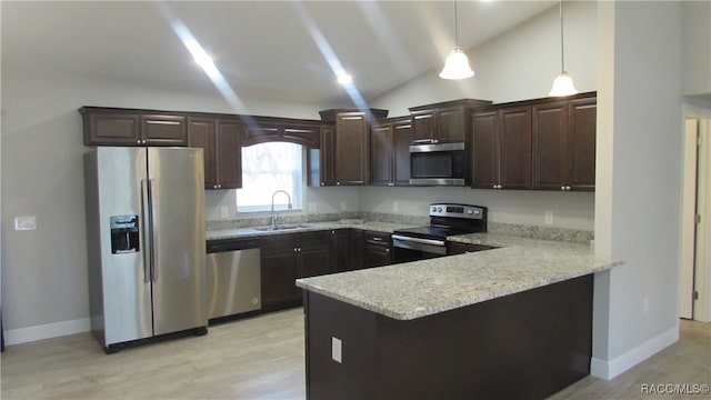 kitchen featuring pendant lighting, kitchen peninsula, lofted ceiling, and stainless steel appliances