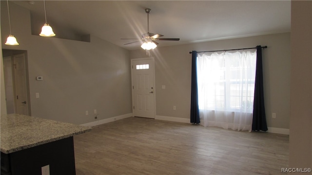 unfurnished living room featuring wood-type flooring and ceiling fan