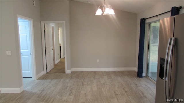 unfurnished dining area with vaulted ceiling, light hardwood / wood-style flooring, and an inviting chandelier