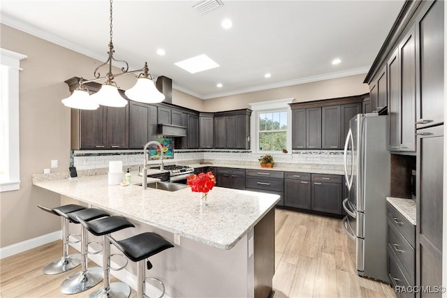 14211 W Saint Martins Rd, Crystal River, FL 34429 - kitchen with visible vents, ornamental molding, freestanding refrigerator, a peninsula, and under cabinet range hood