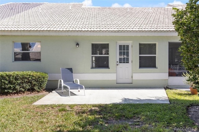 820 Inverie Dr, Inverness, FL 34453 - rear view of property with a tiled roof, a patio area, stucco siding, and a yard