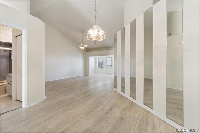 820 Inverie Dr, Inverness, FL 34453 - unfurnished room with a chandelier, wood finished floors, a ceiling fan, baseboards, and high vaulted ceiling