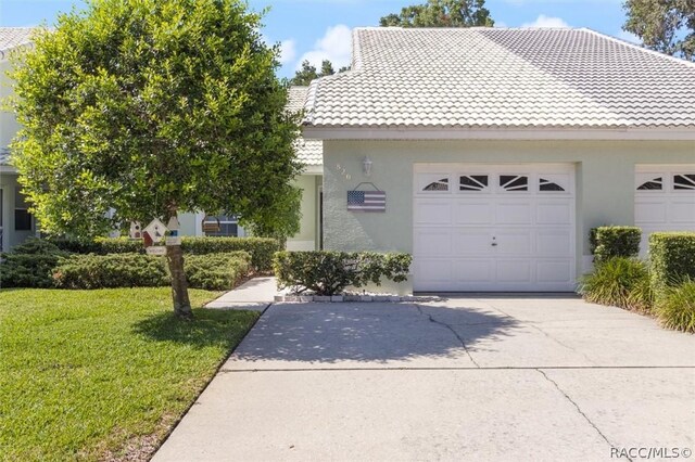 820 Inverie Dr, Inverness, FL 34453 - view of front of home with a tiled roof, driveway, stucco siding, and a front yard