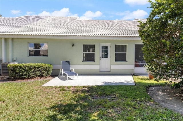 back of property with a yard, a patio, and cooling unit