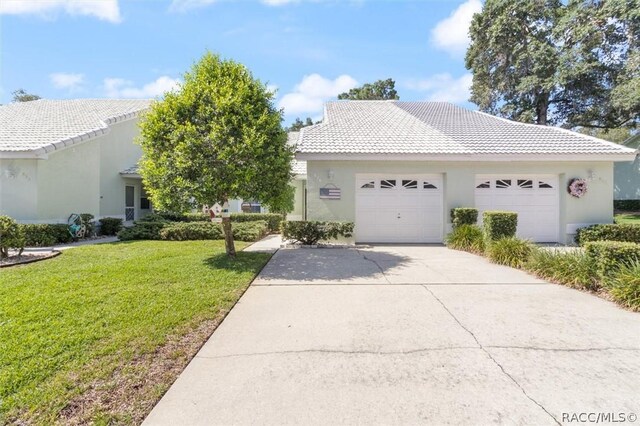 820 Inverie Dr, Inverness, FL 34453 - view of front of property featuring concrete driveway, a front yard, a garage, stucco siding, and a tiled roof