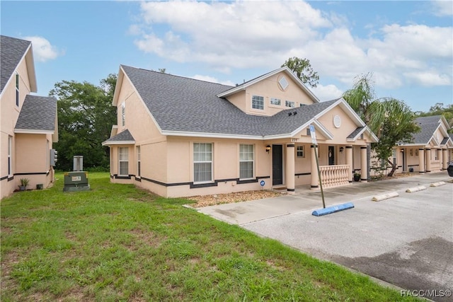 835 N Rembrandt Way, Inverness, FL 34453 - view of front facade with roof with shingles, stucco siding, a porch, and a front lawn