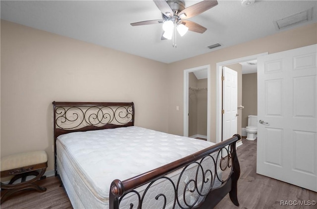 835 N Rembrandt Way, Inverness, FL 34453 - bedroom with wood finished floors, a spacious closet, a closet, ceiling fan, and connected bathroom