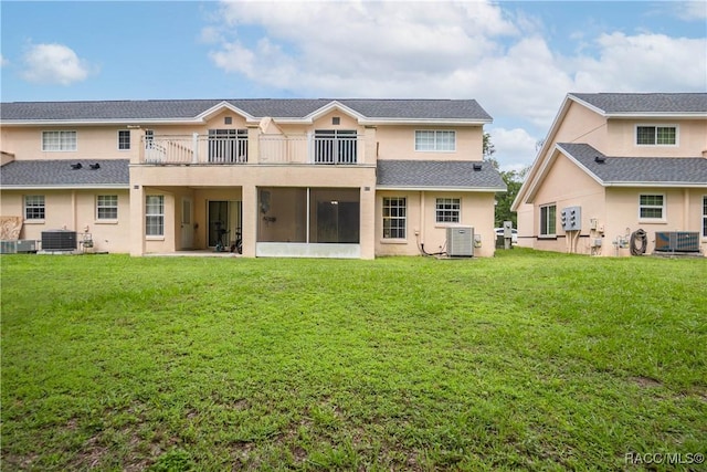 835 N Rembrandt Way, Inverness, FL 34453 - rear view of house with a balcony, stucco siding, a lawn, and a sunroom