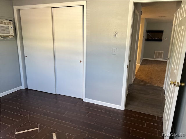 unfurnished bedroom featuring a closet and dark wood-type flooring