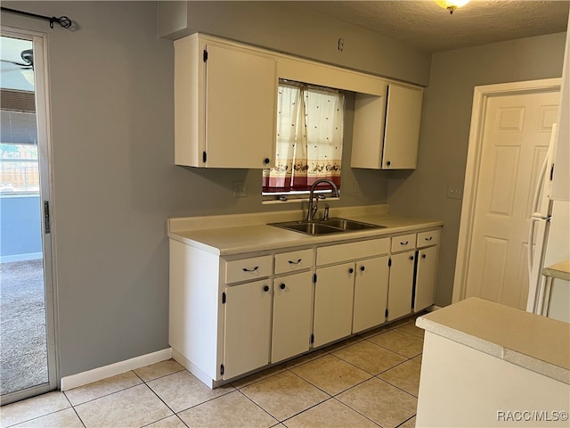 kitchen with a textured ceiling, light tile patterned floors, and sink