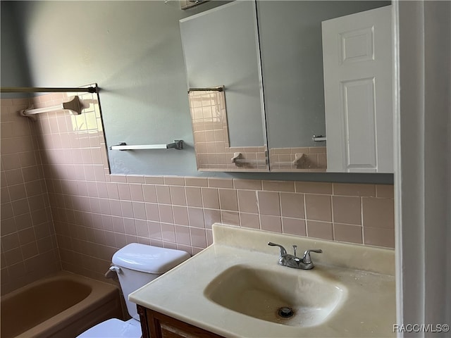 full bathroom with vanity, toilet, tile walls, and tiled shower / bath combo