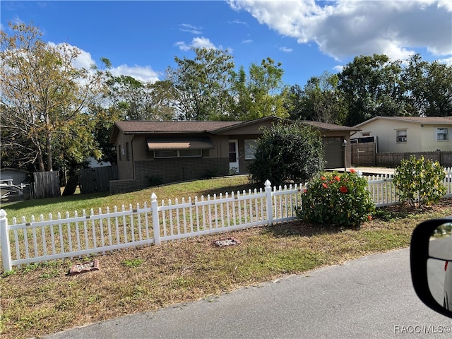 ranch-style house featuring a garage and a front lawn