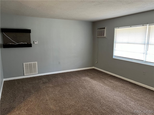 carpeted spare room with a textured ceiling and a wall mounted AC