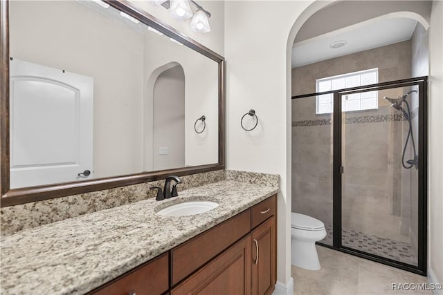 bathroom with vanity, tile patterned floors, a shower with door, and toilet