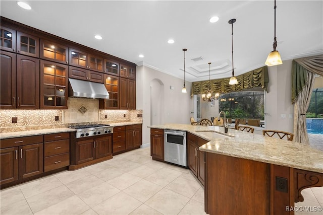 kitchen with appliances with stainless steel finishes, sink, pendant lighting, and a kitchen bar