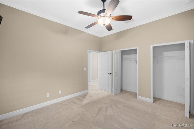 unfurnished bedroom with crown molding, two closets, light carpet, and ceiling fan