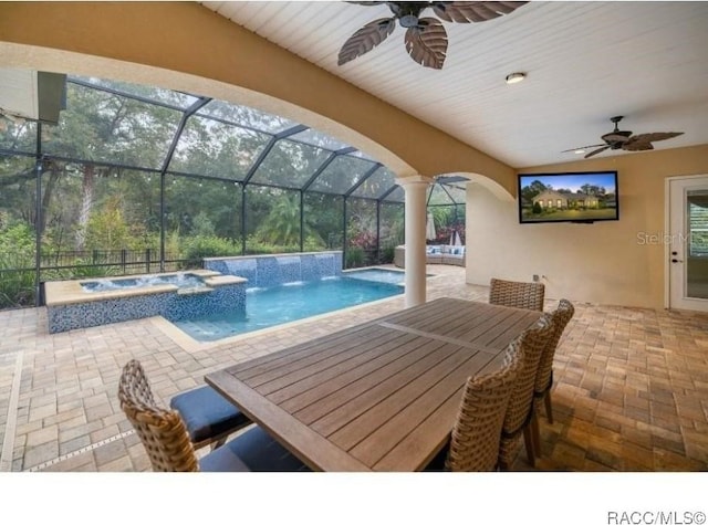 view of pool with pool water feature, a lanai, an in ground hot tub, ceiling fan, and a patio