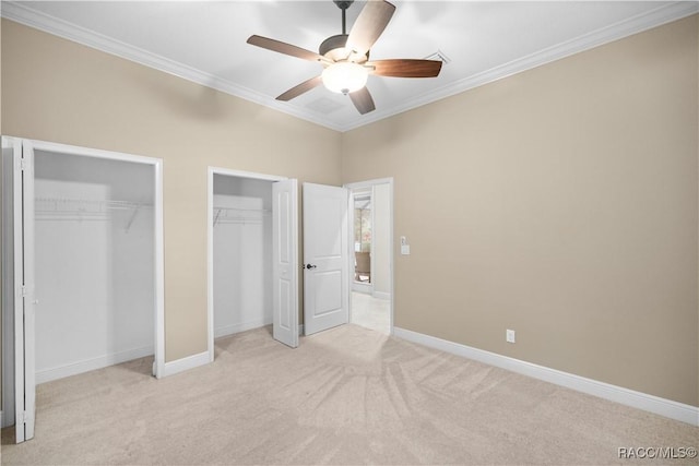 unfurnished bedroom with crown molding, ceiling fan, light carpet, and two closets