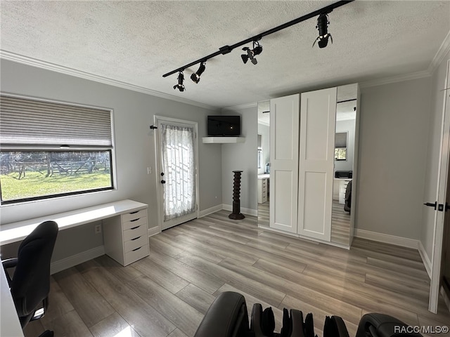 office with a textured ceiling, light wood-type flooring, and rail lighting