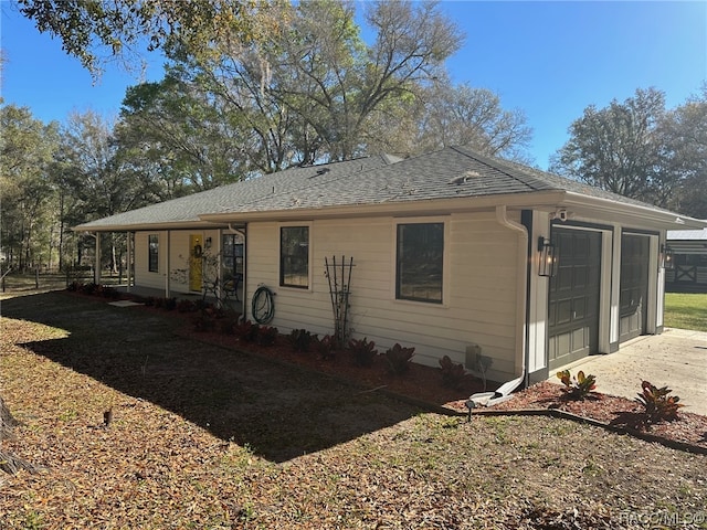 view of property exterior with covered porch and a garage