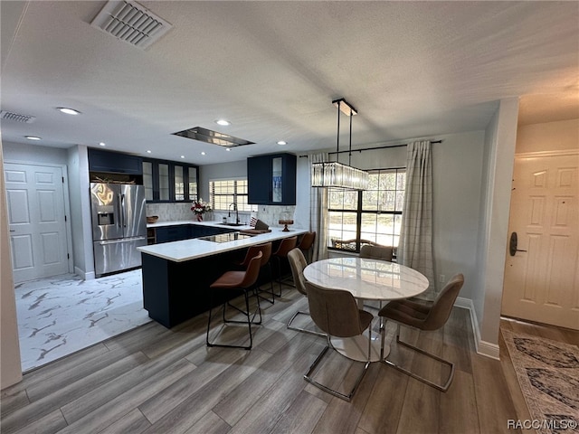 dining area featuring hardwood / wood-style floors, a textured ceiling, and sink