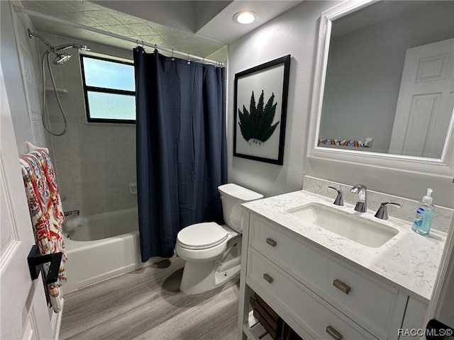 full bathroom featuring toilet, vanity, hardwood / wood-style flooring, and shower / tub combo with curtain