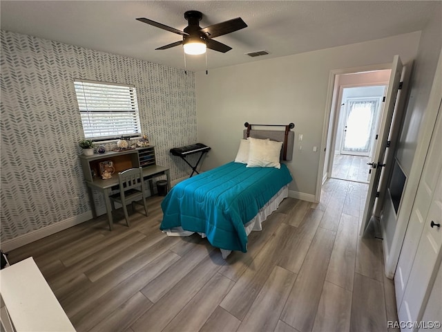 bedroom with ceiling fan and wood-type flooring