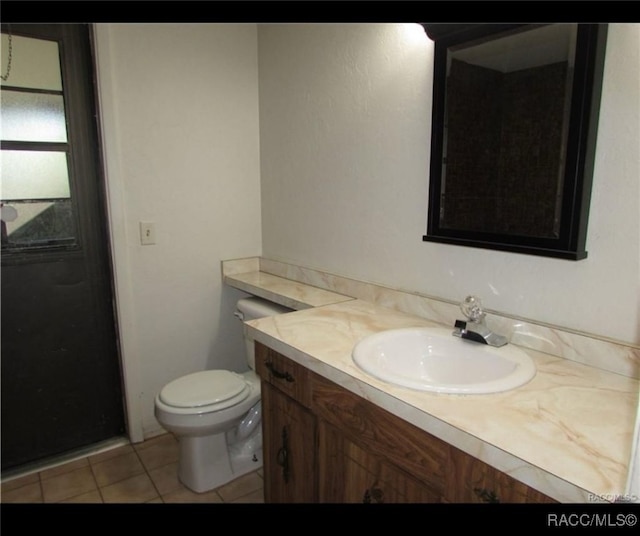 bathroom featuring tile patterned floors, toilet, and vanity