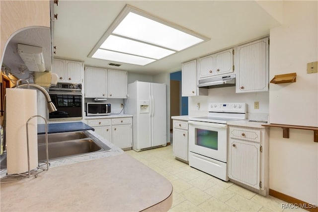 5761 S Eaton Ter, Inverness, FL 34452 - kitchen featuring white appliances, under cabinet range hood, light countertops, baseboards, and a sink