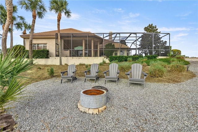 rear view of house featuring a lanai and a fire pit