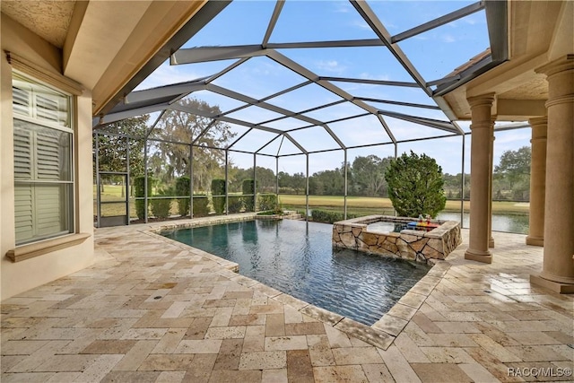 view of pool with an in ground hot tub, a water view, glass enclosure, and a patio